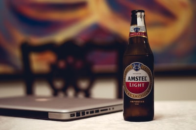 阿姆斯特尔轻型啤酒瓶附近的笔记本电脑